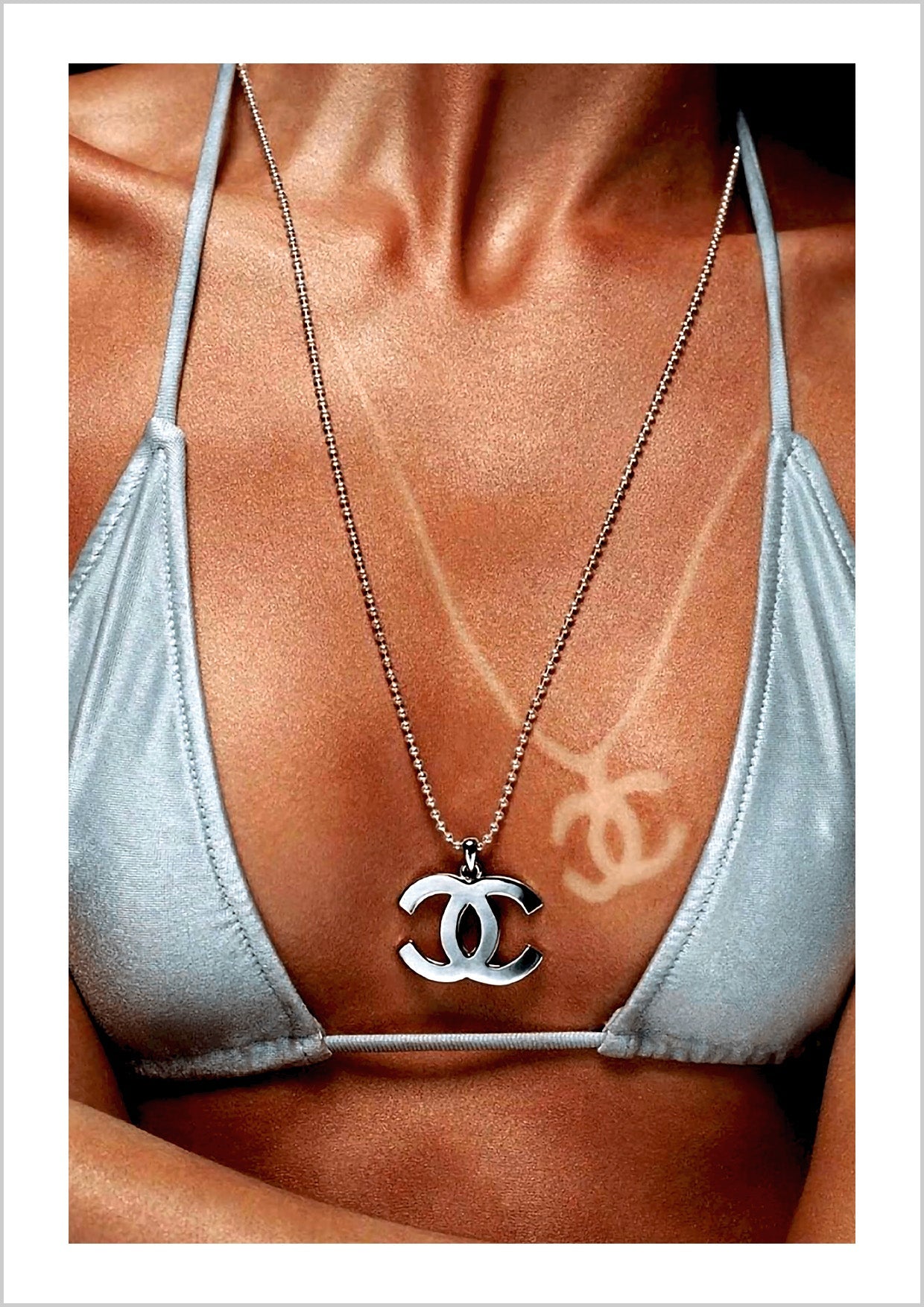 a girl wearing a Coco Chanel necklace, with sun-kissed tan lines