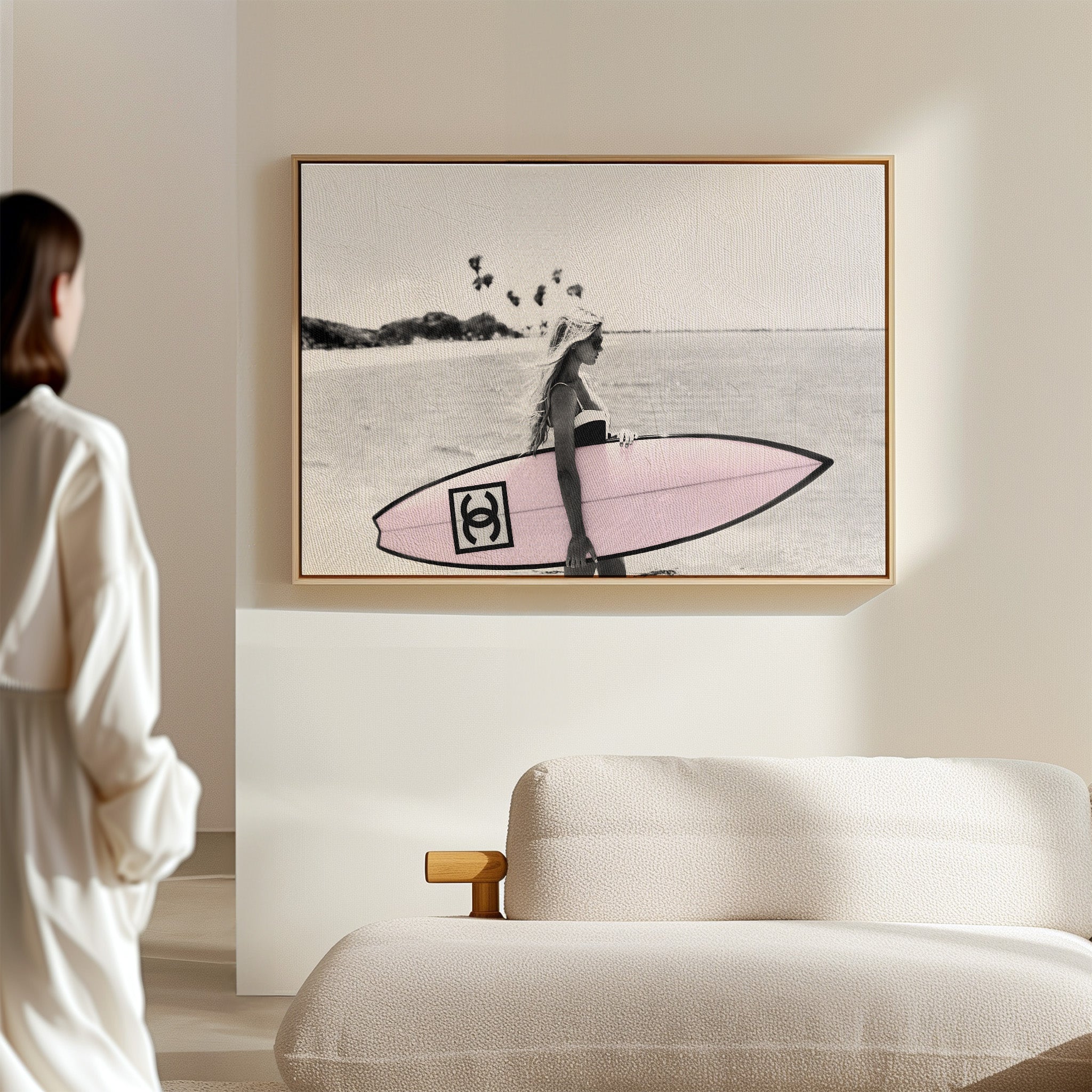 Photograph of a bikini girl holding a Chanel surfboard toward the sea.
