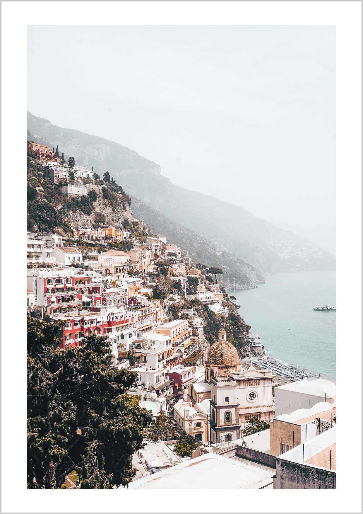 Pink houses in the city Positano. Photograph of the small city Positano surrounded by water and mountains.