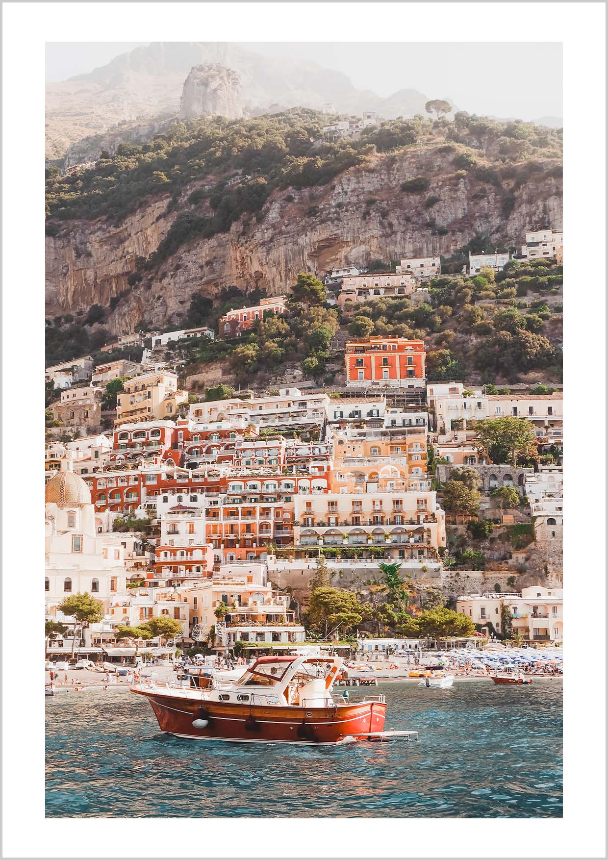 Pink houses in the city Positano. Photograph of the small city Positano surrounded by water and mountains.