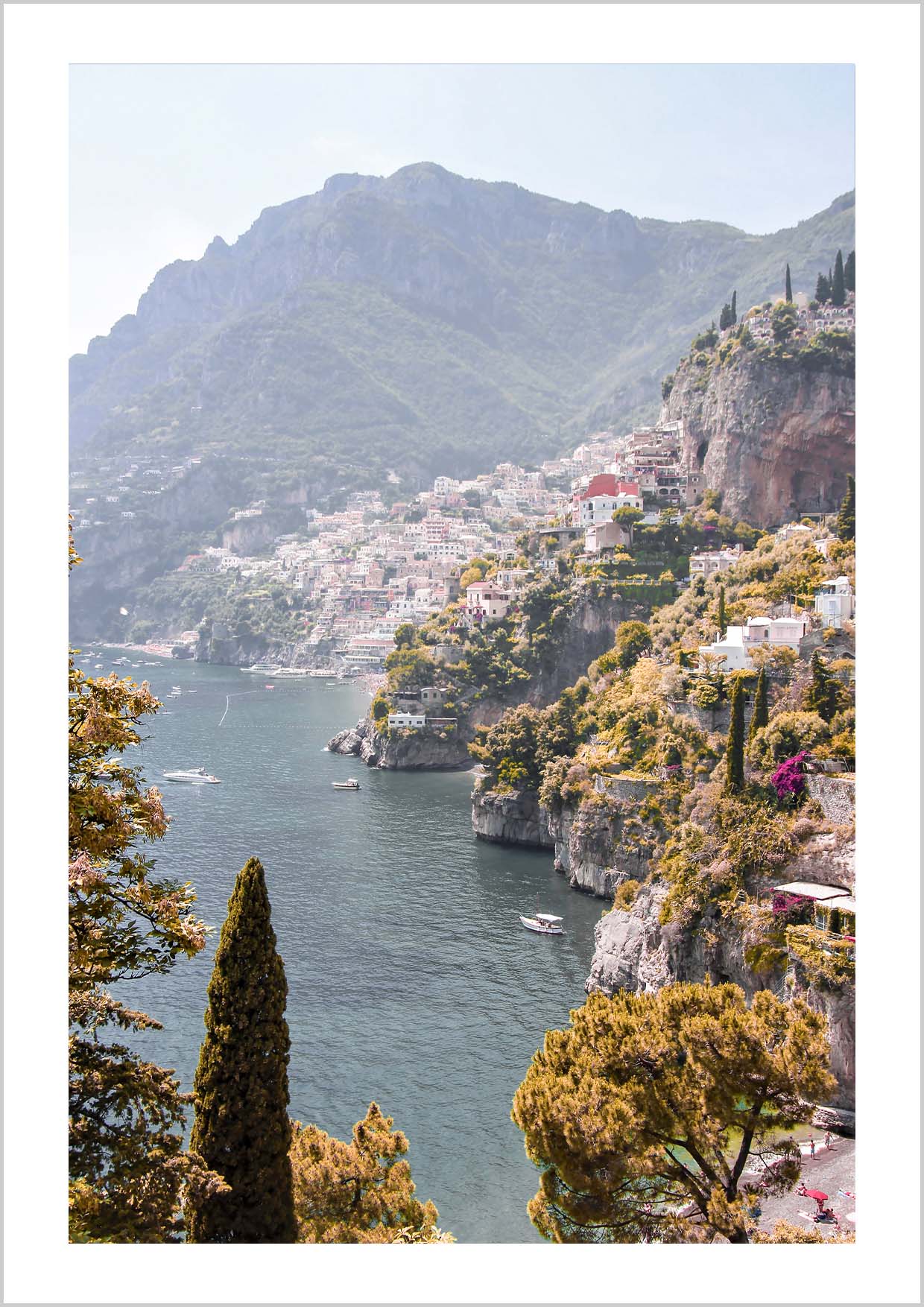 Pink houses in the city Positano. Photograph of the small city Positano surrounded by water and mountains.
