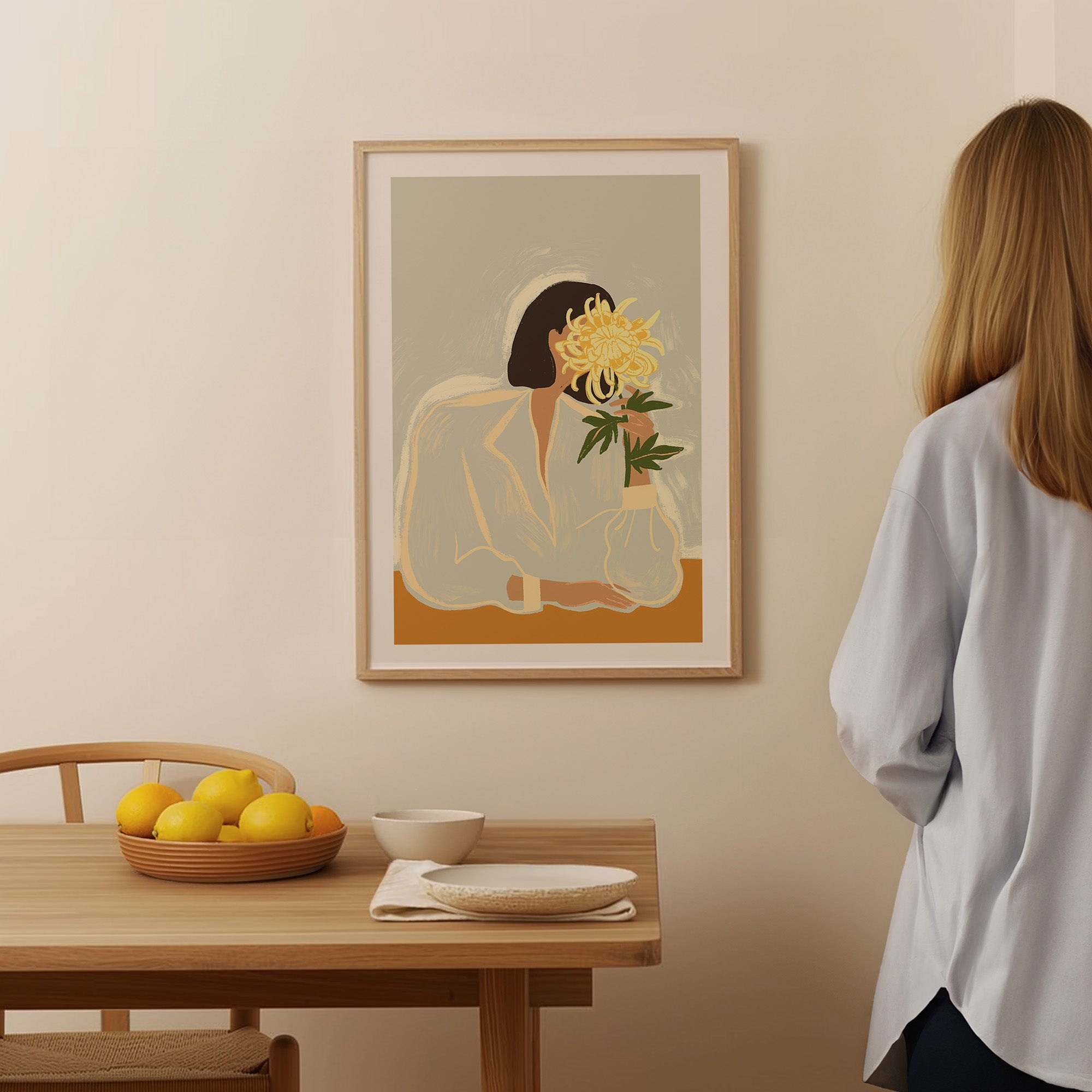 woman leans into a bloom of yellow chrysanthemum, her face half-hidden behind the petals. Soft lines and muted tones give it an easy elegance — part mystery, part beauty.
Artist: Arty Guava