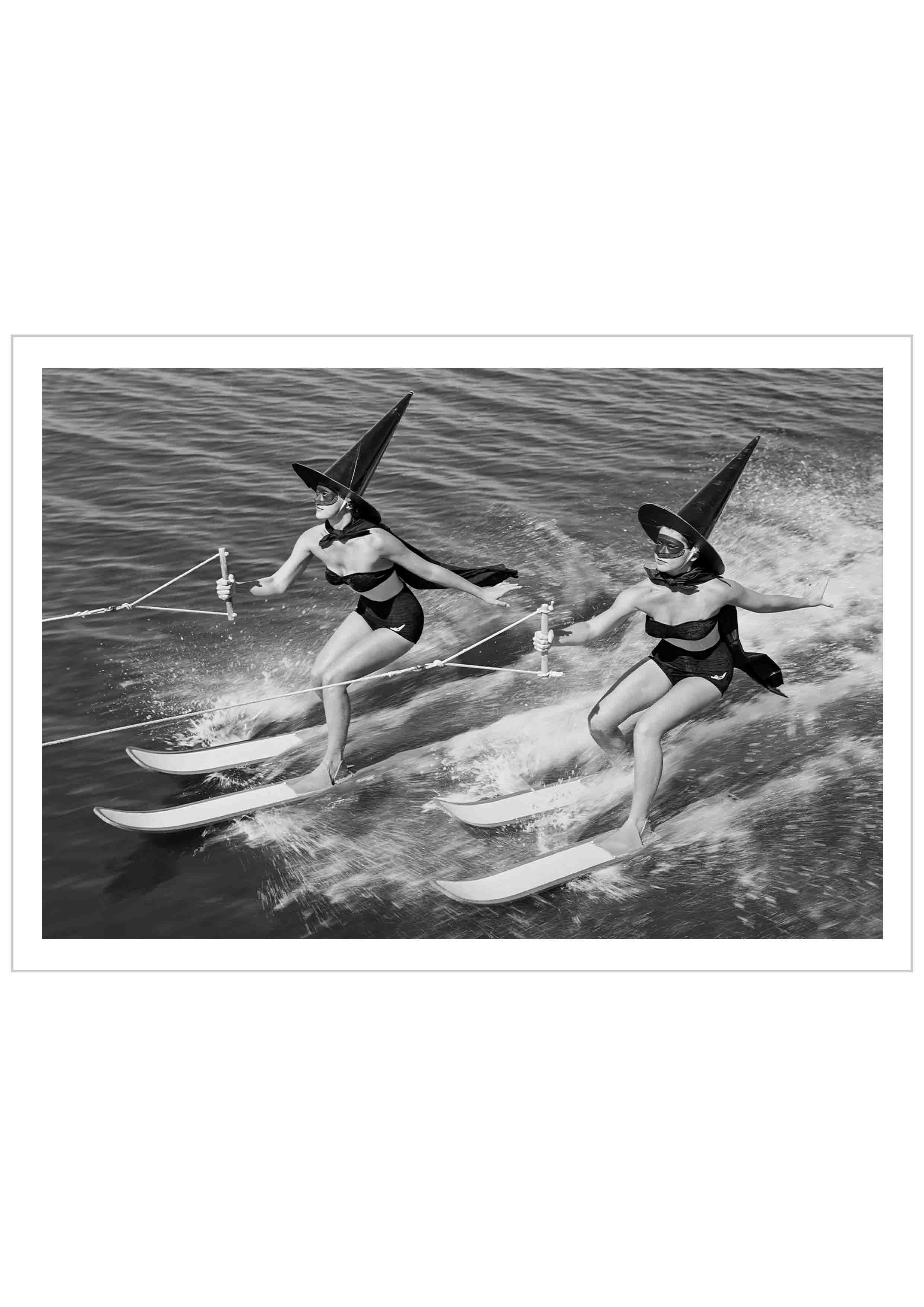 Monochrome photography Poster of 2 women water skiing wearing a witch's disguise.