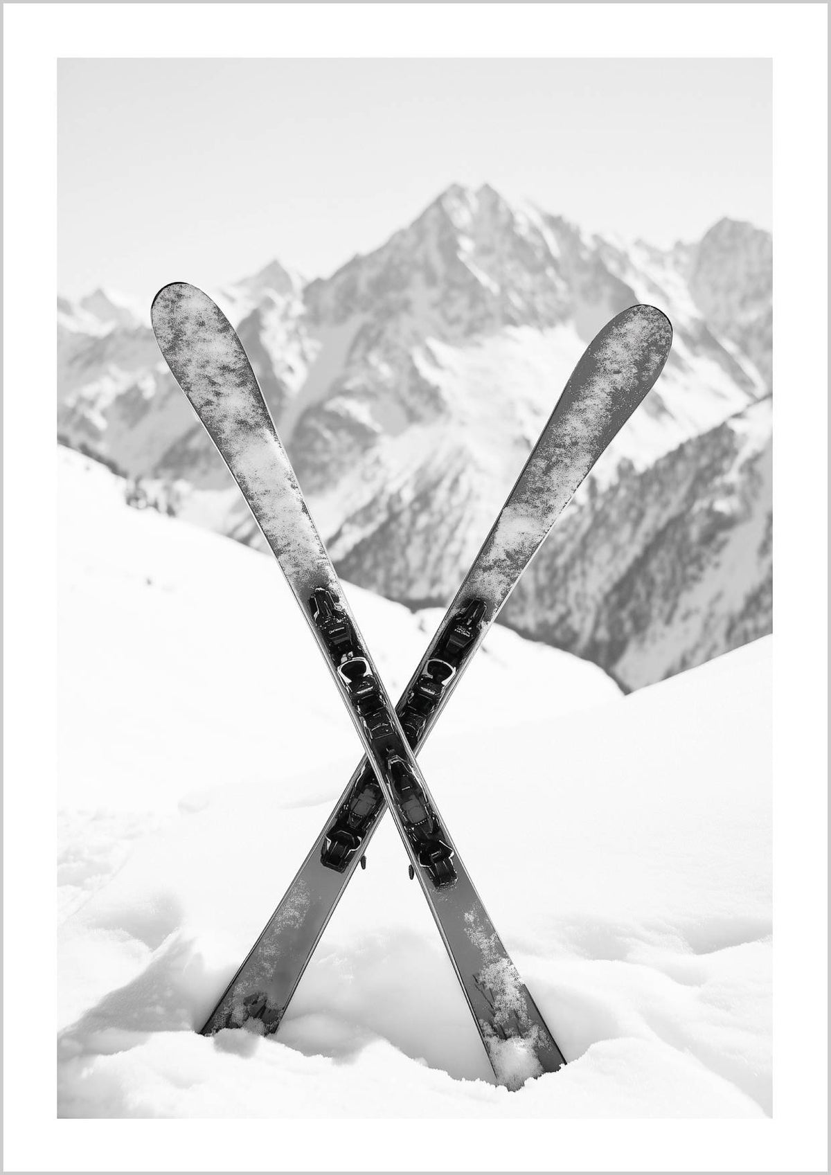A pair of crossed skis in fresh snow with snowy mountains in the background. – Arteve Gallery