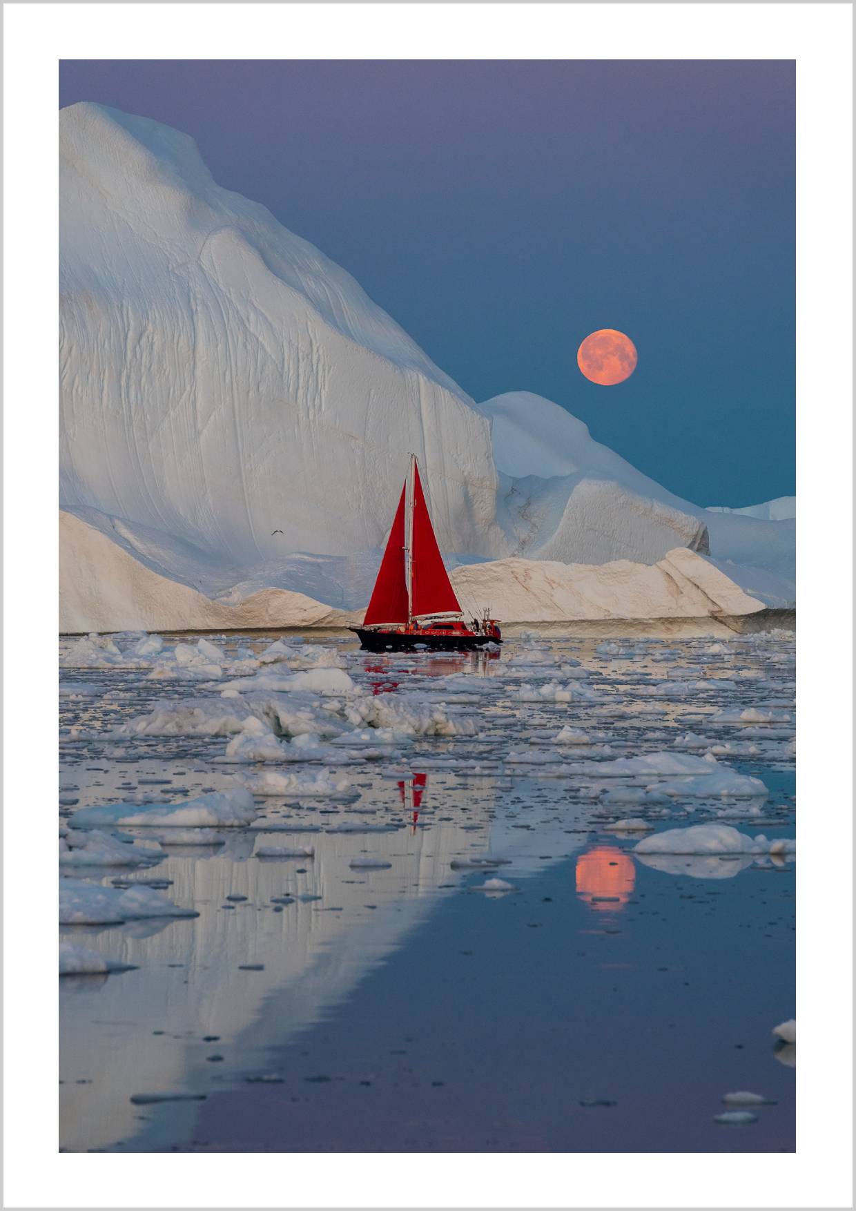 A red sailboat navigating icy waters with a large, glowing moon in the background and white icebergs surrounding. – Arteve Gallery