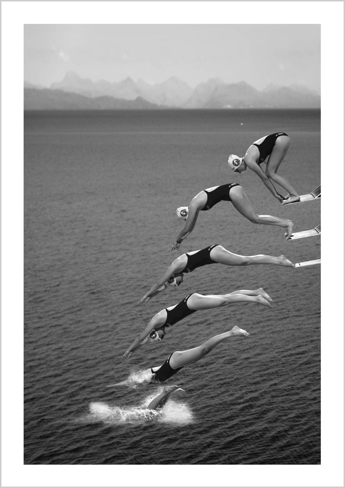 A sequence of a female diver captured mid-air above a calm sea, showcasing various stages of her dive against a backdrop of mountains. – Arteve Gallery