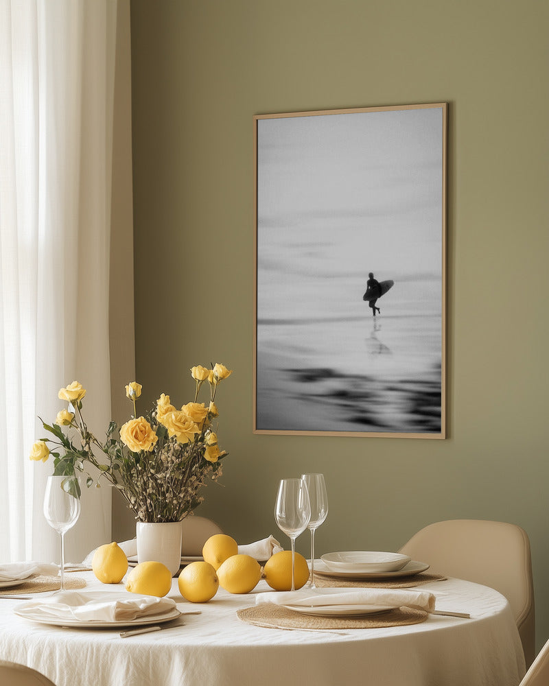 A silhouette of a surfer walking on the beach, with gentle waves and a blurred background. – Arteve Gallery