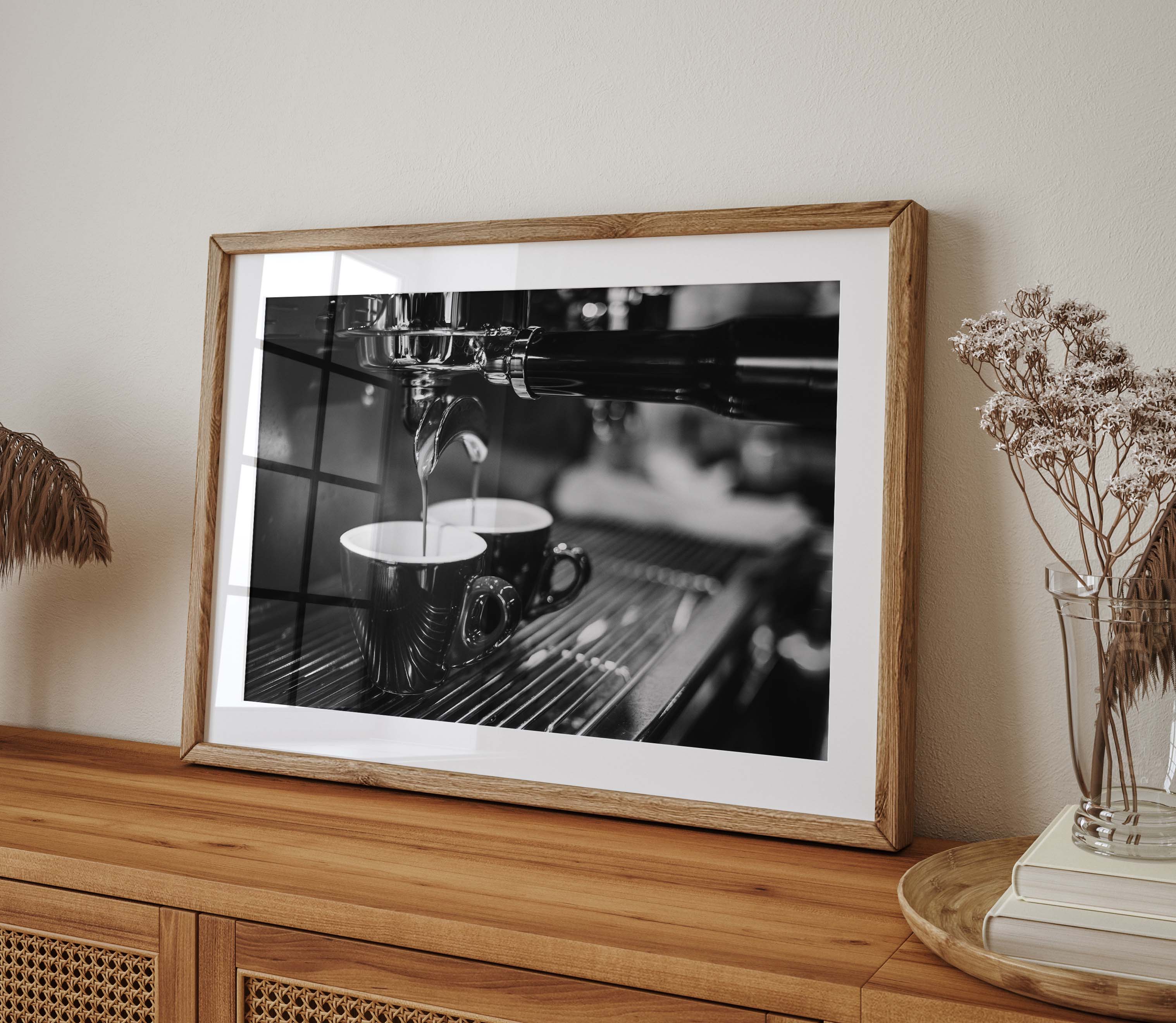 Close-up photograph in black and white of coffee dripping out of an espresso machine. This print is perfect for the coffee lover who wants to add a high-end look to their kitchen space.