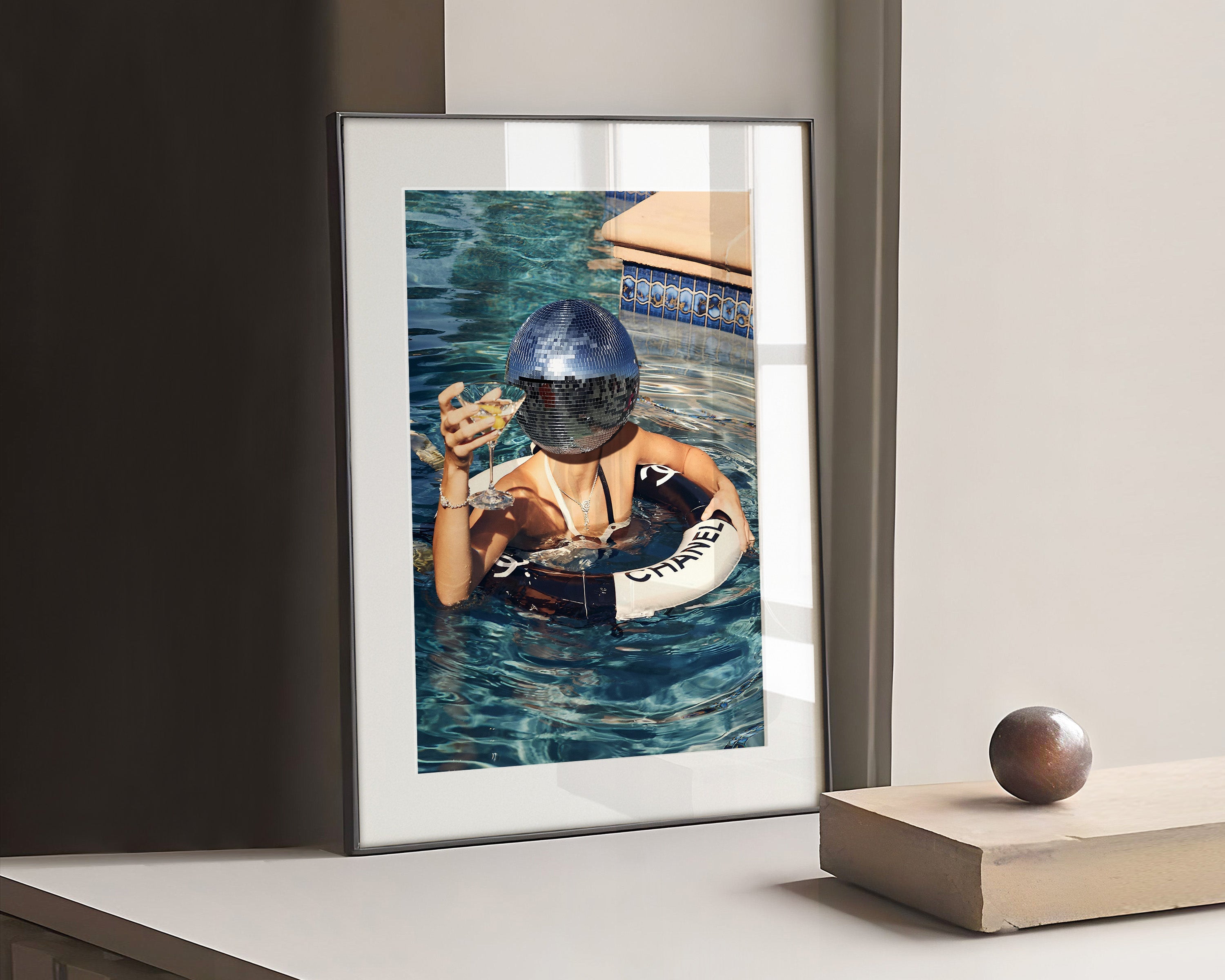 Photograph a woman drinking in a Chanel lifebuoy with a disco ball.