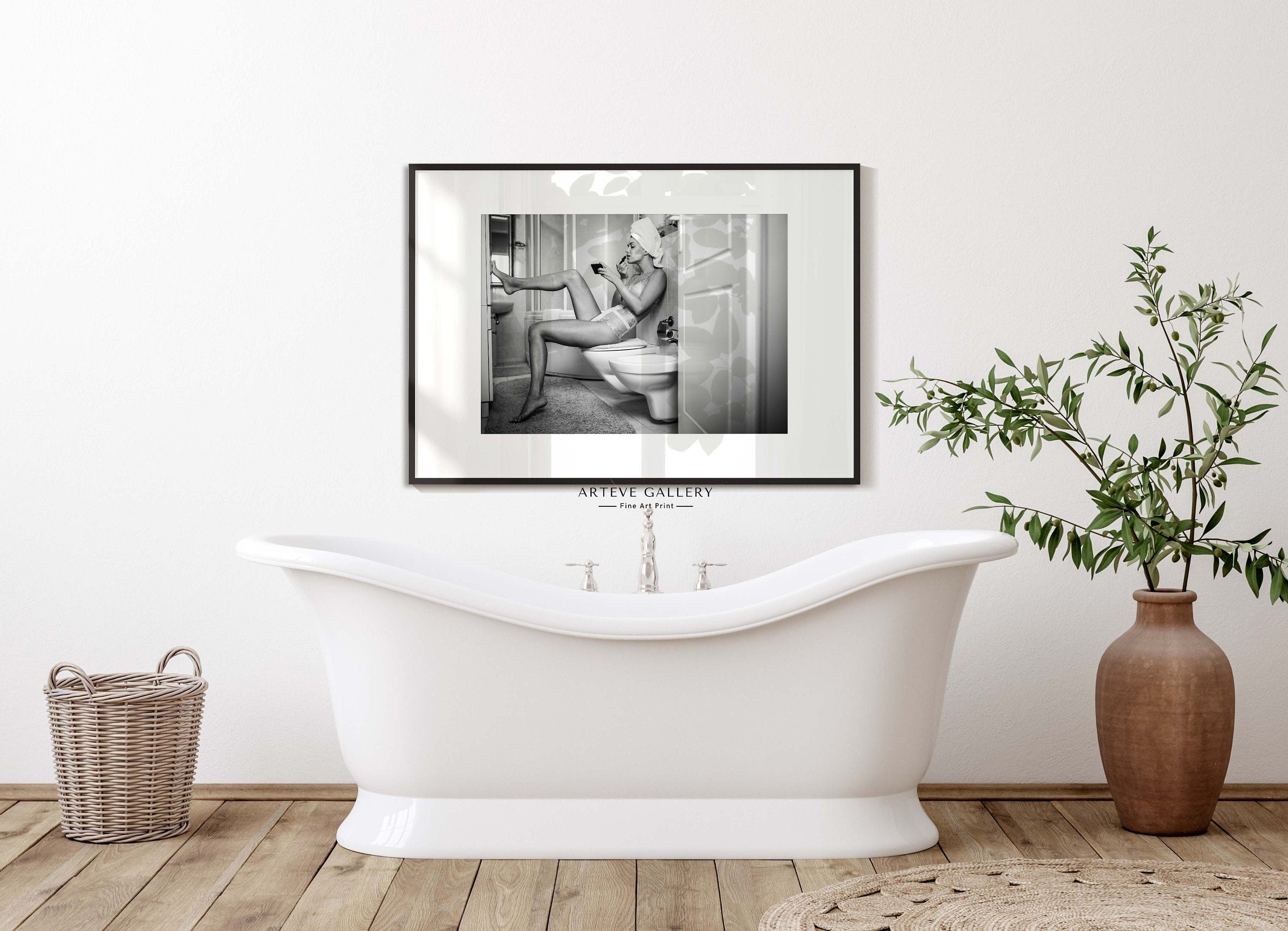 Black and white photograph of a woman resting her foot on a wall whilst putting on lipstick