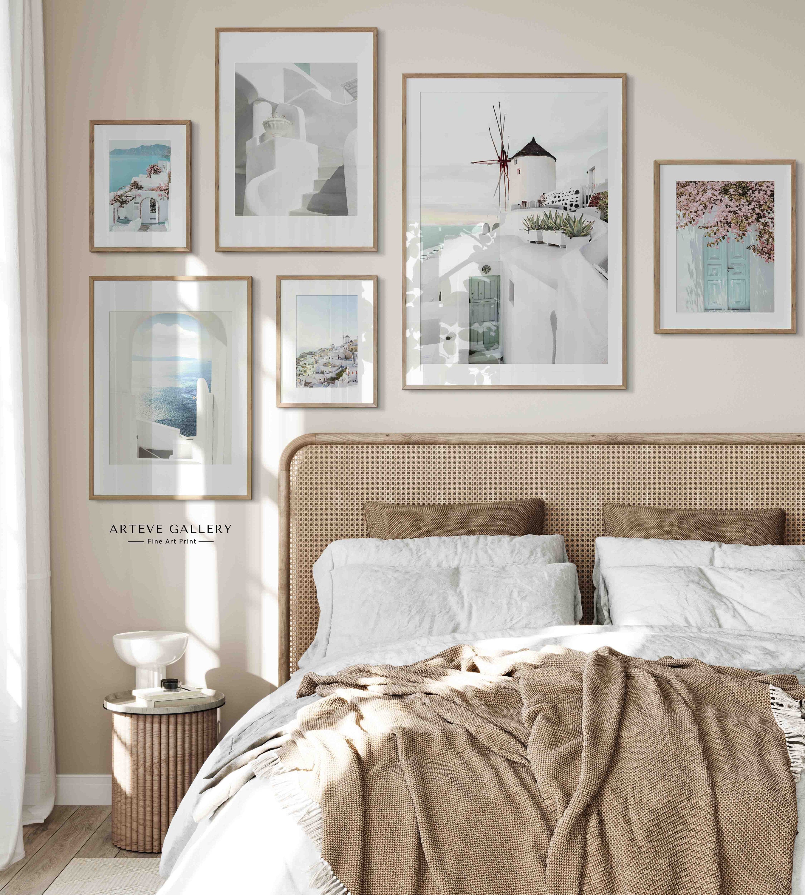 A beautiful landscape poster with a view of the Greek island of Santorini and the crystal clear blue sea. The traditional white house facades are decorated with pink flowers and make the Poster radiate.