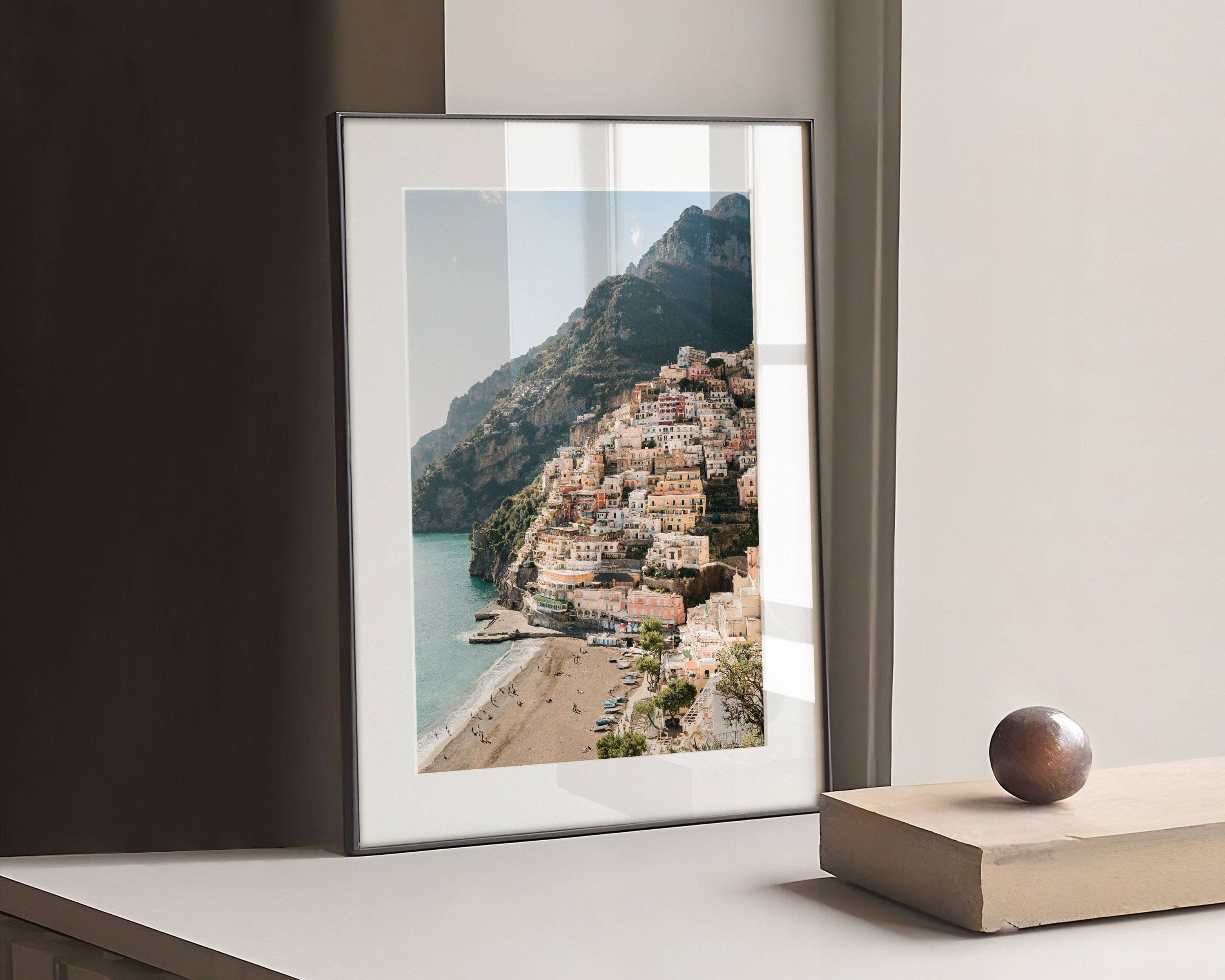 Pink houses in the city Positano. Photograph of the small city Positano surrounded by water and mountains.
