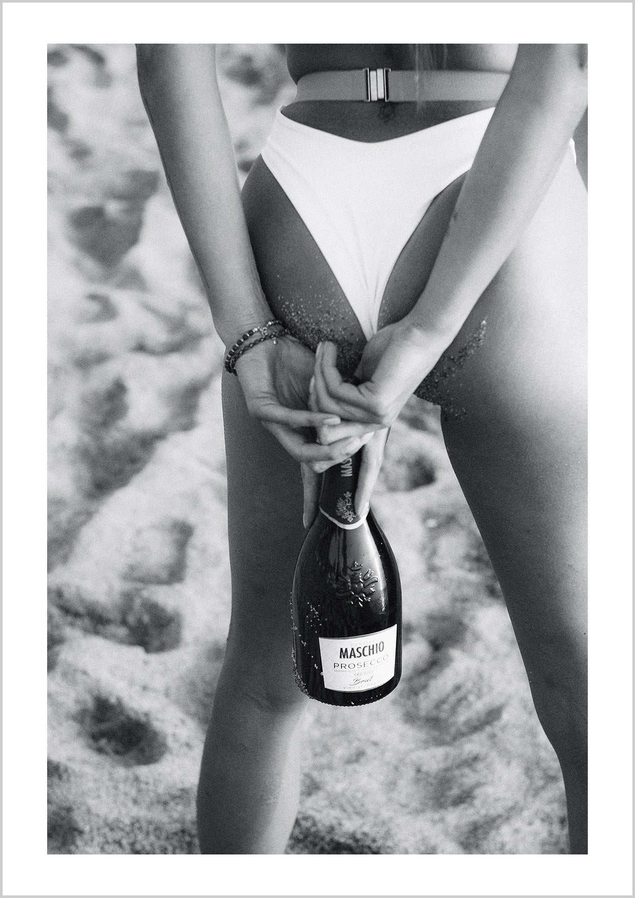 Photography print of a sexy woman holding a bottle of Maschio Prosecco Trevino, ready for a beach party.