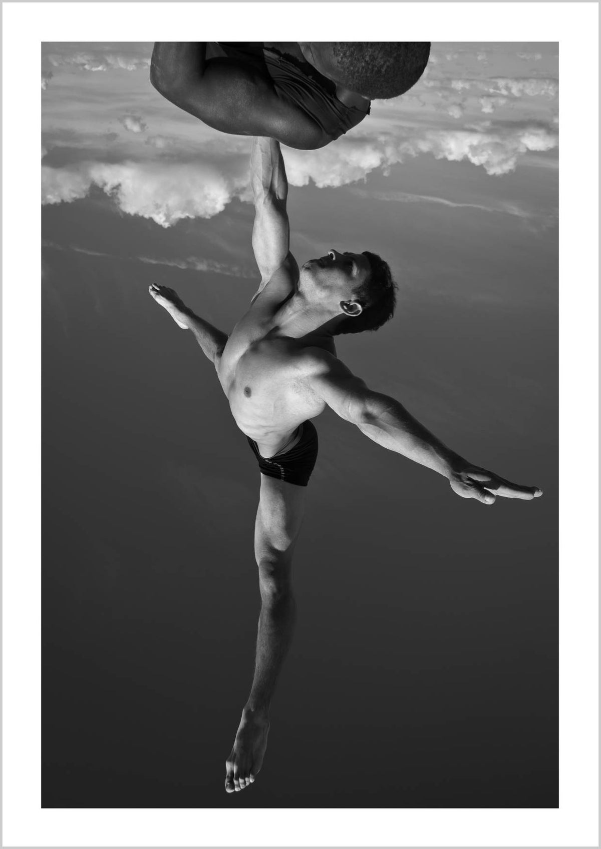 A male dancer in mid-air, striking an acrobatic pose with arms and legs extended, set against a cloudy sky. – Arteve Gallery