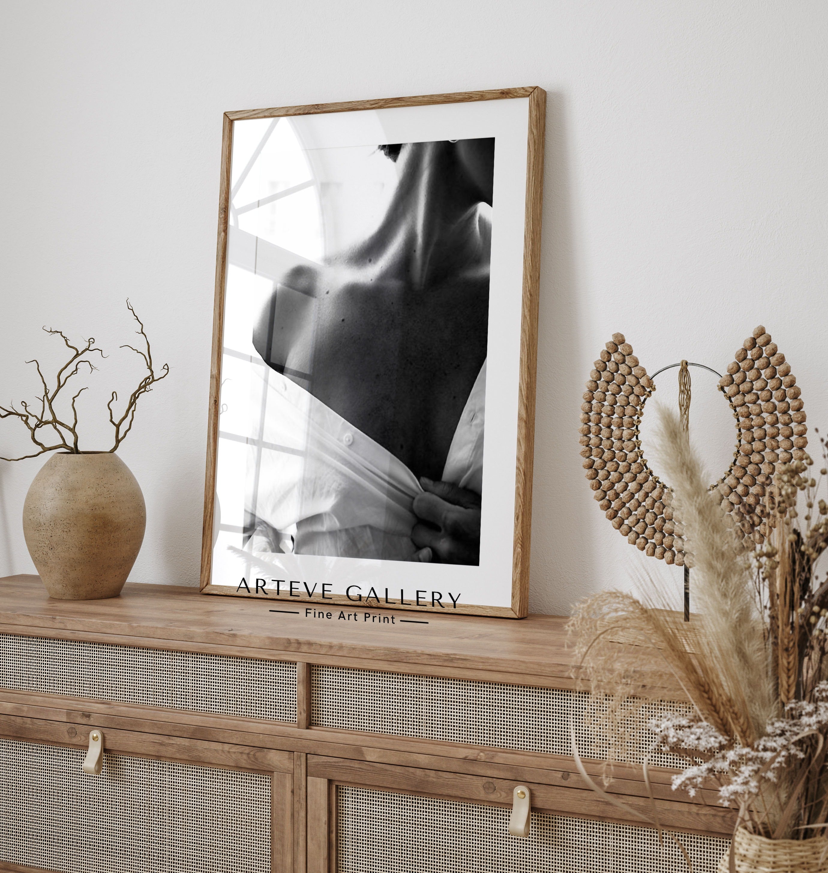 Photograph in black and white of a woman in a white shirt showing her shoulder. Sensual photo art is a style we love, and this Poster fits well with both other black and white photographs as well as botanical Posters.